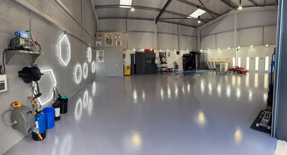 The ALC Elite workshop wash area, with wall-mounted hose reels, a pressure washer and hexagonal lighting