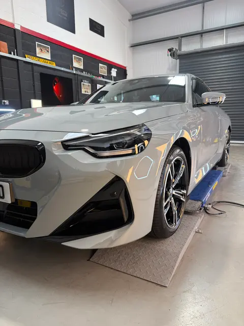 The front of a grey BMW 220 coupé on a ramp in the ALC Elite workshop