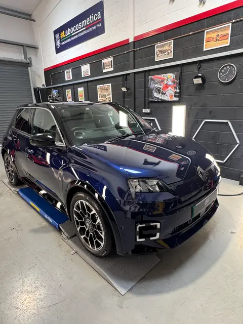 A dark blue Renault 5 on a ramp in the ALC Elite workshop