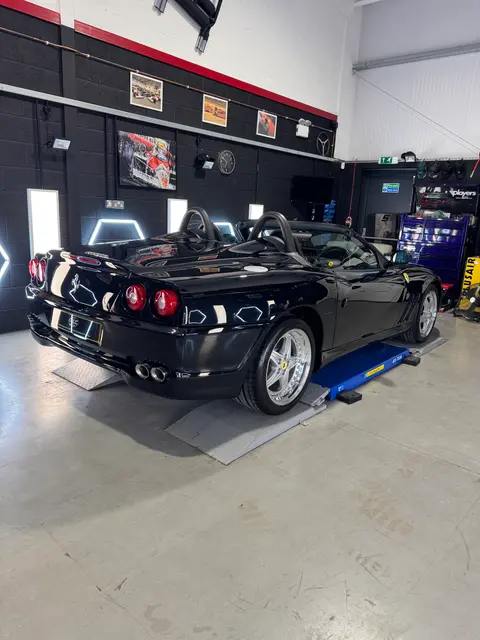 A black convertible sports car in the ALC Elite workshop, with interior and engine bay details